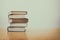 Stack of books on desk with vintage filter blur background
