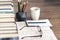 Stack of books education background, open textbook and notebook, glasses, pens and pencils in holder, cup of tea with lemon