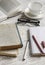 A stack of books, notebook and glasses , coffee cup on white wooden table.