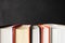 Stack of books with selective focus on black background with copy space. Banner format. Home education, learning