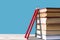 A stack of books and two red wooden pencils on a blue background, stairs, climbing books, getting knowledge, back to school
