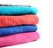 Stack of bright terry towels on white background