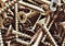 Stack of bronze wood  steel  screws. Close up macro, industrial seamless background