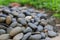 Stack of brown-black circular stones Focus point selection The stone background and lawn are blurred