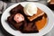 Stack of brownie squares with scoop of ice cream and caramel