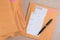 Stack of bubble wrap padded mailing envelopes and pen on white b