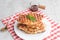 Stack of Caramelized Croissant Waffle or Croffle served in white plate.