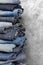 A stack of carelessly folded jeans on gray background. Close-up of jeans in different colors. Copy space