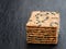 Stack of cheese and pumpkin seed organic crispbread on black stone background