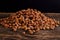 Stack of cherry stones on an old wooden board, black background