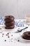 Stack of chocolate donuts on light background. Vertical format