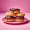 Stack of chocolate donuts on a pink plate