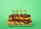 Stack of chocolate frosted donuts on plate with 2022 candles