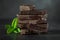 Stack of chocolate slices with mint leaf on a wooden table.Assortment of fine chocolates in white, dark, and milk chocolate. Sweet