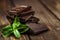 Stack of chocolate slices with mint leaf on a wooden table.Assortment of fine chocolates in white, dark, and milk chocolate. Sweet