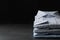 Stack of classic shirts on dark grey stone table. Space for text