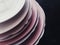 Stack of clean empty plates on black background, dishware and table decor