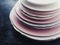 Stack of clean empty plates on black background, dishware and table decor