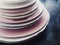 Stack of clean empty plates on black background, dishware and table decor