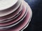 Stack of clean empty plates on black background, dishware and table decor