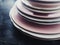 Stack of clean empty plates on black background, dishware and table decor