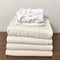 Stack of clean freshly laundered, neatly folded women\\\'s clothes on wooden table.