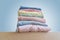 Stack of clean freshly laundered, neatly folded women's clothes on wooden table