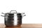 Stack of clean saucepans on table against white background