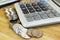 The stack of coin with calculator on wood table at office, concept of calculating expenses