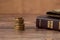 Stack of coin money, holy bible book and old wallet on wooden table, a closeup