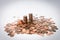 A stack of coins at the white background surrounded by other coins spilled around