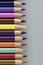 A stack of colored pencil points against a gray background