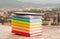Stack of colorful books with electronic book reade