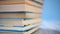 Stack of colorful books in hard and soft cover on a blue bright background