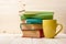 Stack of colorful books, open book and cup on wooden table. Back to school. Copy space