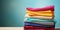 Stack of colorful clothes. Pile of clothing on table empty space background. Laundry and household