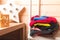 Stack of colorful fleece jackets lays in a wooden room