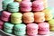 A stack of colorful macaroons on a plate.