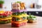 stack of colorful meal prep containers with various foods