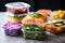 stack of colorful meal prep containers with various foods