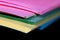 Stack of colorful papers on black background