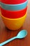 Stack of colorful plastic bowl with blue spoon