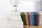 Stack of colorful quilting fabrics in basket on the background of sewing machine