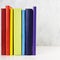 Stack of colorful rainbow books on white background. Copy space