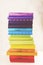 Stack of colorful rainbow books on white background. Toned