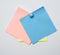 Stack of colorful stickers pinned by blue button on white background