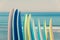 Stack of colorful surfboads on ocean background with waves