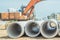 Stack of concrete drainage pipes for wells water discharges laying an external sewage system at a construction site