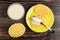 Stack of cookies, condensed milk in spoon on cookie in saucer, bowl with condensed milk on wooden table. Top view