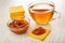 Stack of crackers, cup with tea, bowl with apple jam, cookie with jam on table